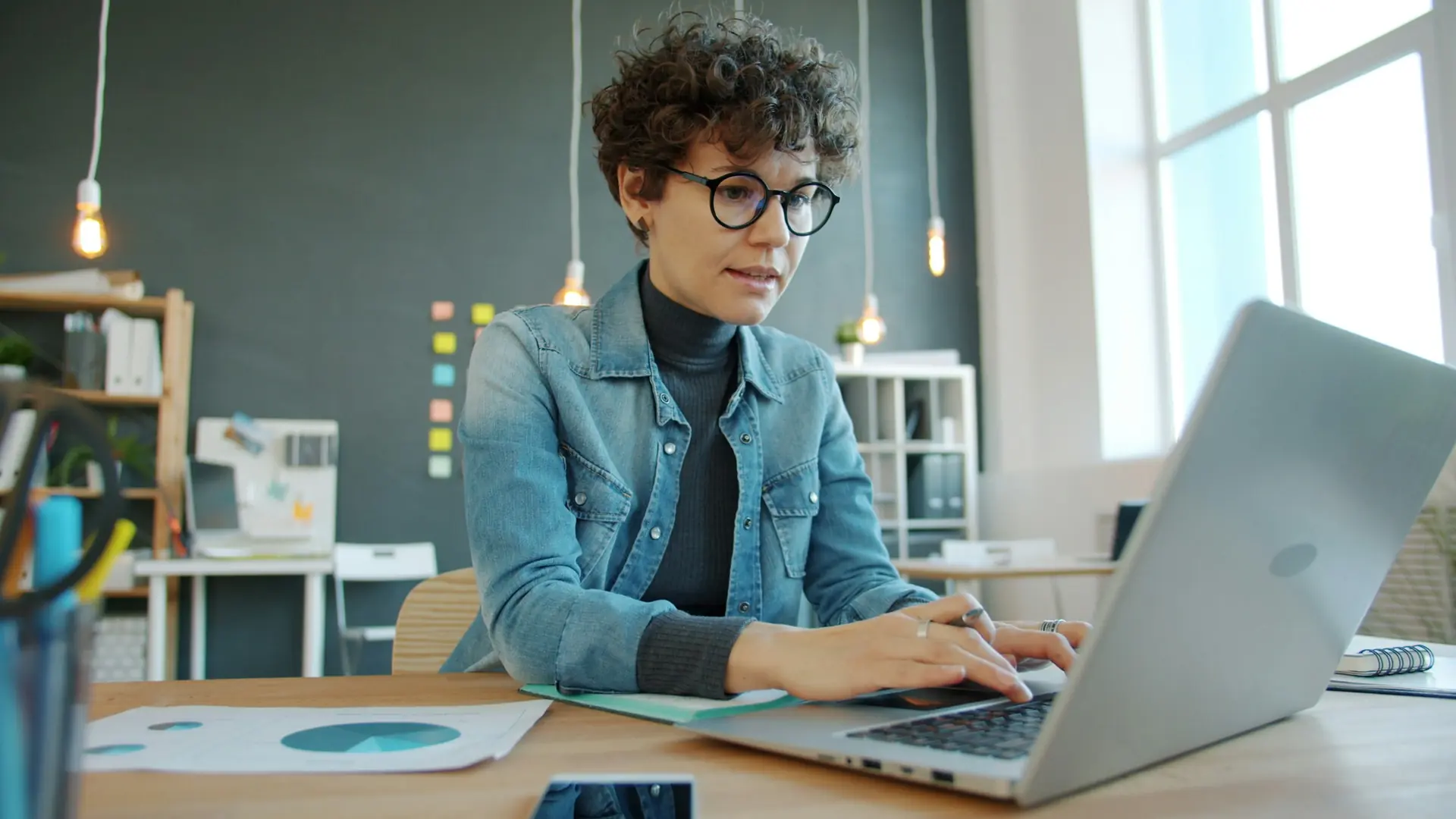 A business owner working at a laptop in a bright office